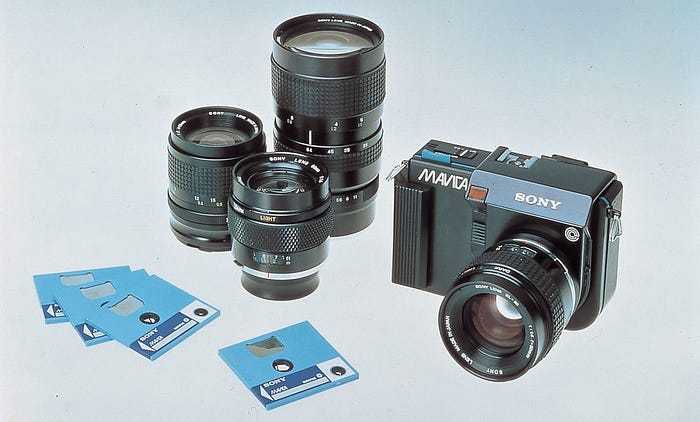 Product photo of the Sony Mavica camera (right), three lenses and four 2in floppy disks.