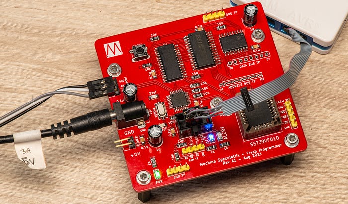 Photograph of a red printed circuit board with various cables plugged into it.