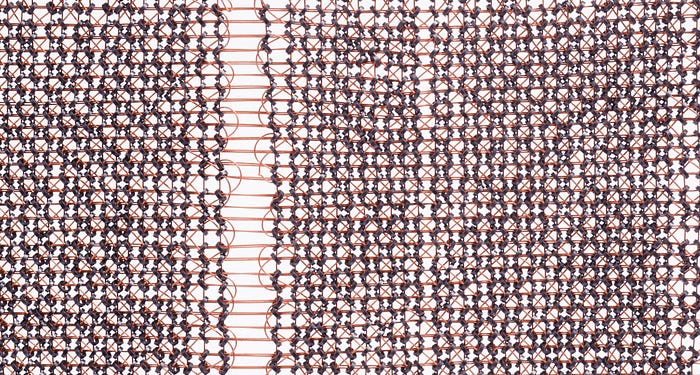 Close-up photograph of a matrix of metal rings strung on vertical and horizontal wires.