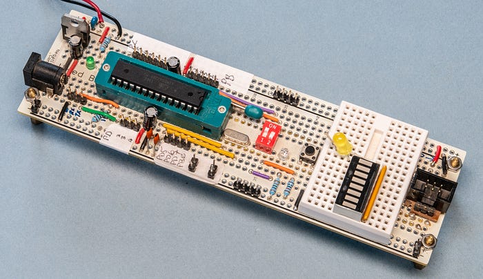 Photograph of an electronic circuit created on prototyping board, including a chip in a turquoise socket.