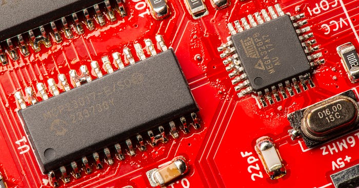 Another close-up photograph of two chips on a PCB. Again, there are visibly solder bridges between some of the pins.