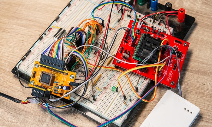 Photograph of an electronics prototype consisting of a large breadboard with several chips and two PCBs all connected by a rat’s nest of wires.