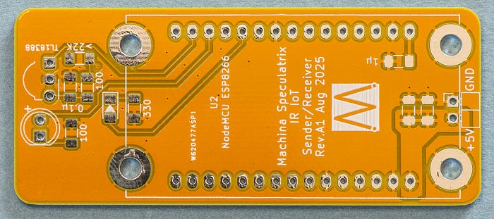 Close-up photograph of a yellow PCB with no components attached with the words: NodeMCU ESP8266 Machina Speculatrix IR IoT Sender/Receiver Rev.A1 Aug 2025.